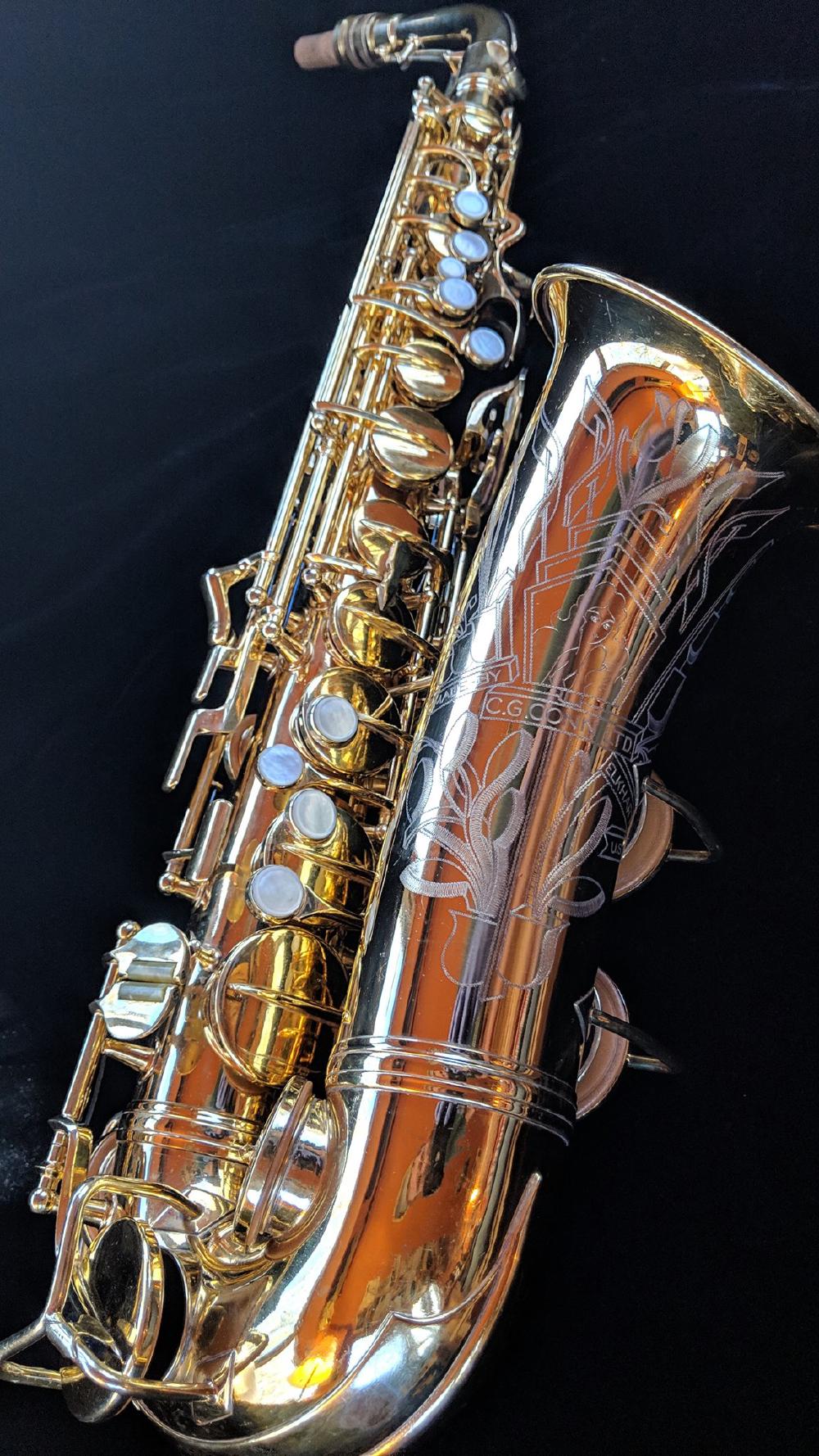 Burnished gold plate Conn 6M transitional. This engraving pattern would later become the 26M/30M pattern, with the addition of textured hair.