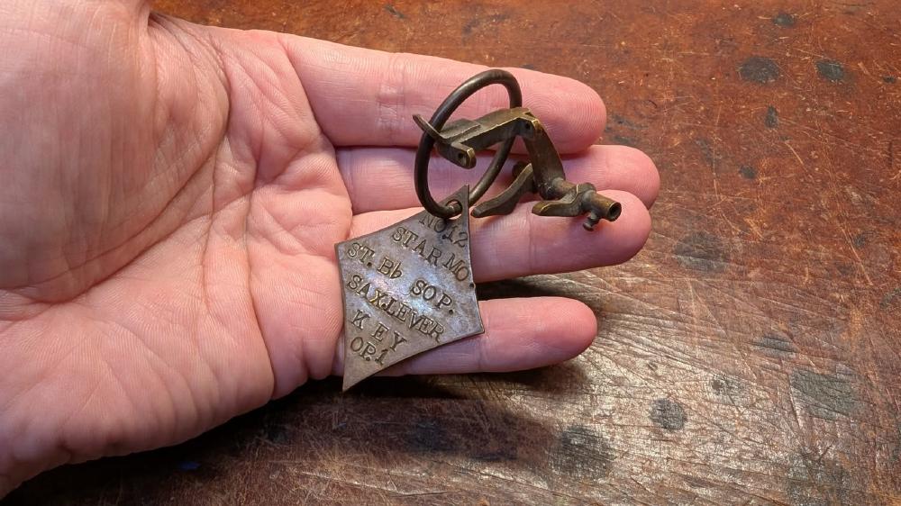 'Master' from the Buescher factory, G# key. This would have hung on a board in the factory and was used to check that the jigs and machines were in spec. Star Model, Straight Bb Soprano, Sax Lever Key, Operation 1.