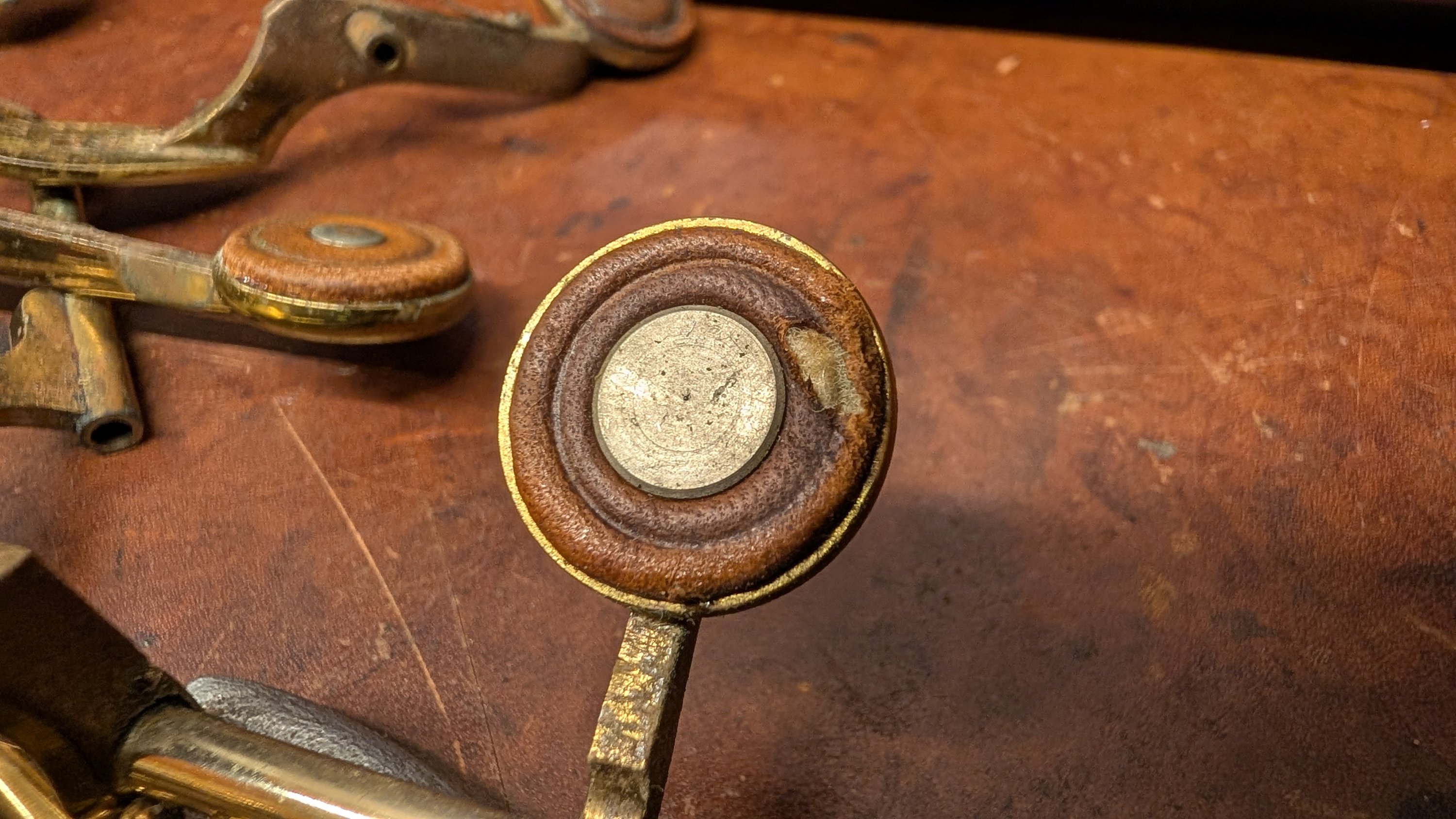 The large flat rivet used on palm keys in place of a reusable tone booster, off a Mark VI alto around serial 78,000 that had metal tone boosters everywhere else on the horn. It sits flush and does not come off the pad in one piece. I think it is a modified brake pad rivet.